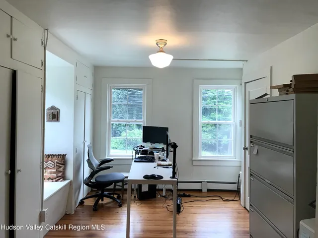 a view of a livingroom with workspace and a window