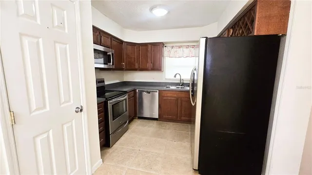 a kitchen with stainless steel appliances granite countertop a refrigerator and a sink