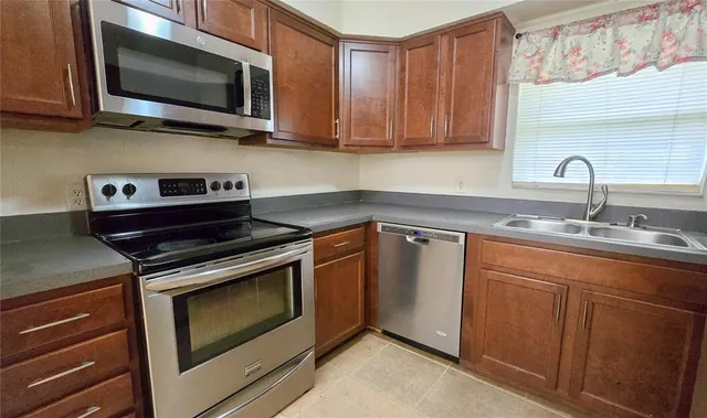 a kitchen with stainless steel appliances granite countertop a stove microwave and sink