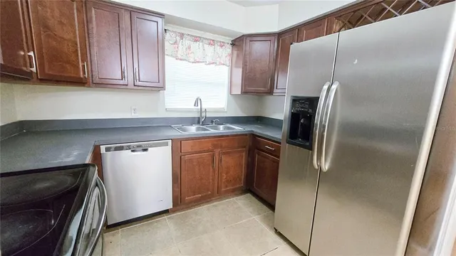 a kitchen with stainless steel appliances granite countertop a refrigerator and a sink