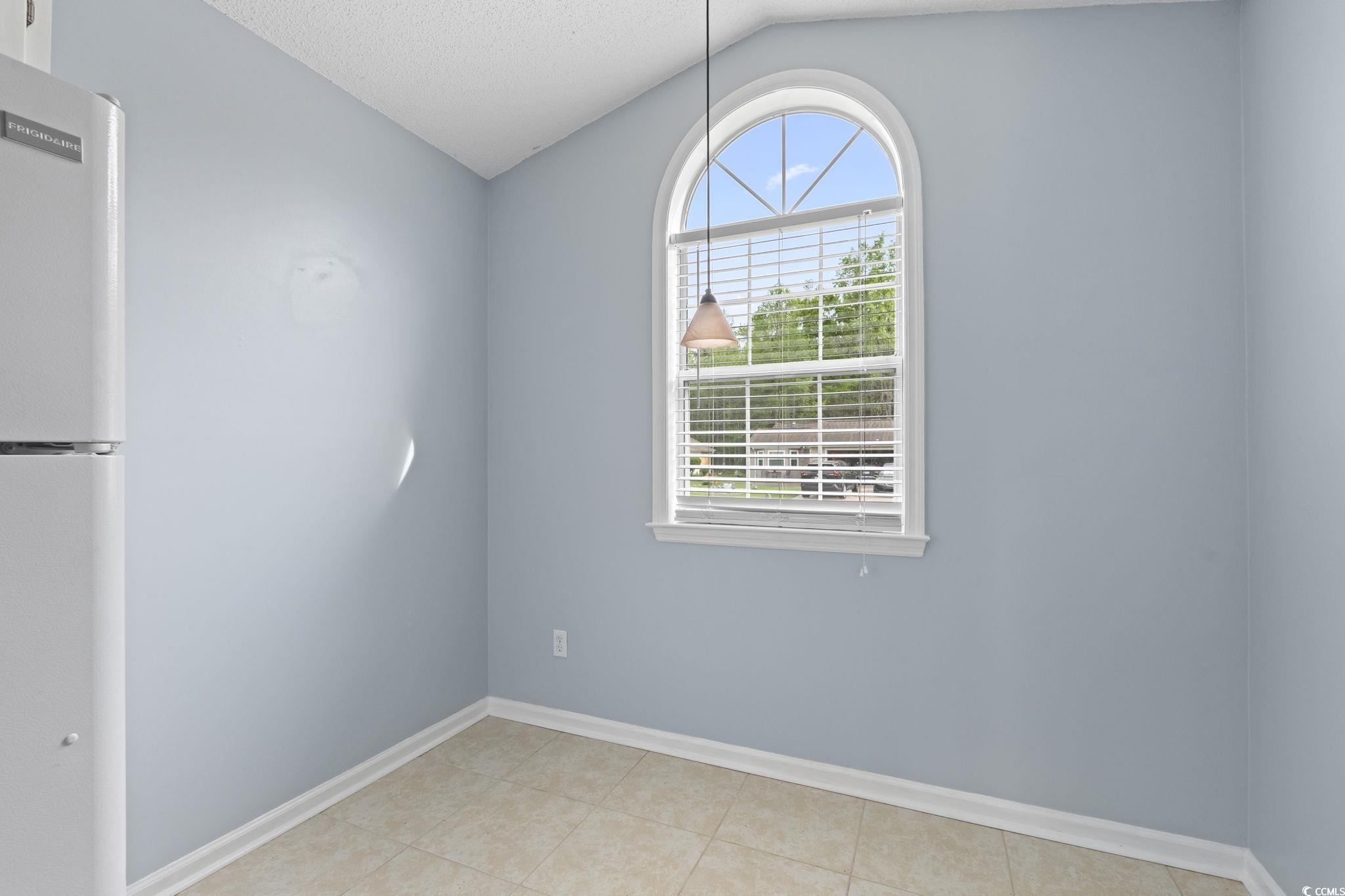 1130 Ganton Way Myrtle Beach, SC 29588 - Photo 6 of 30 Unfurnished room with tile patterned floors, baseboards, a textured ceiling, and lofted ceiling
