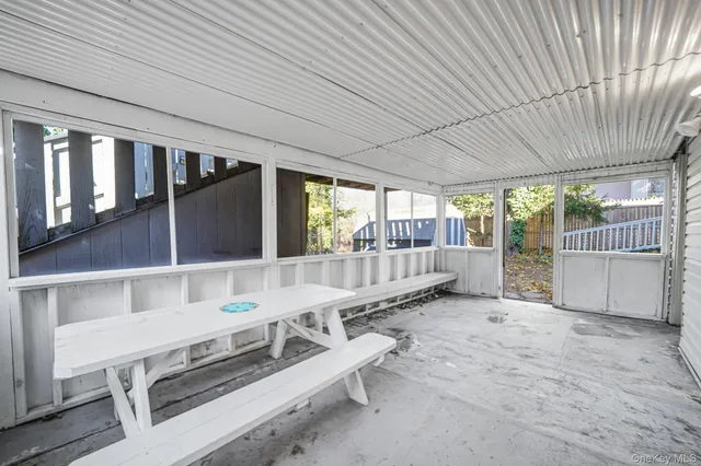 a view of a porch with furniture and floor to ceiling window