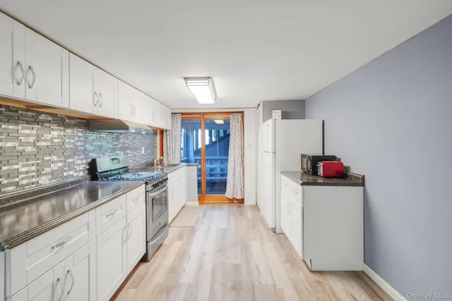 a kitchen with granite countertop white cabinets and white appliances