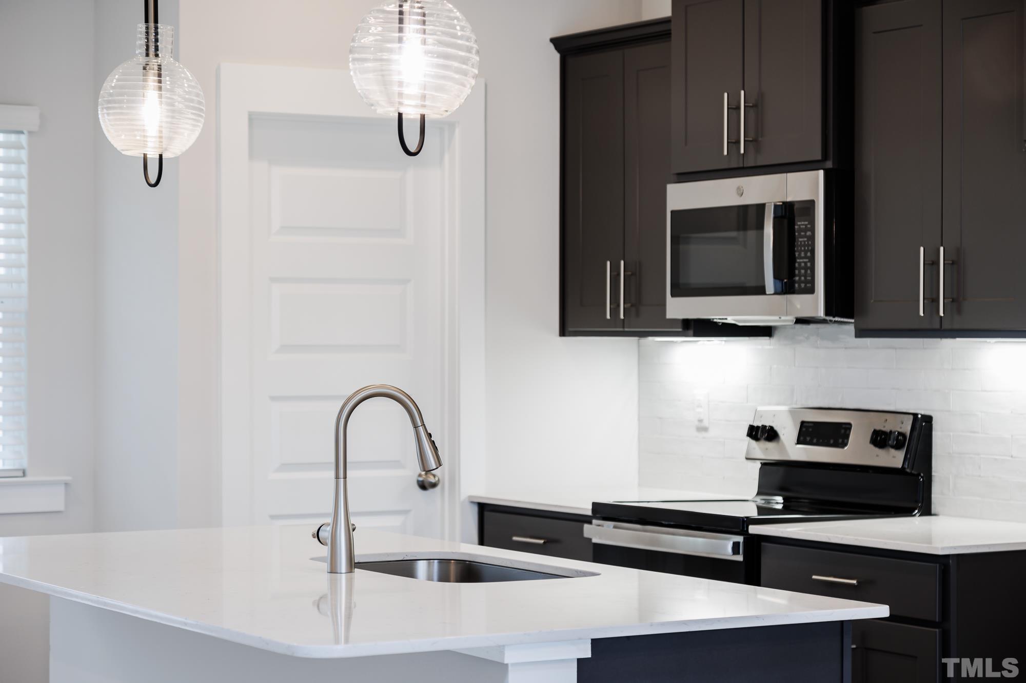 8514 Silsbee Drive Raleigh, NC 27613 - Photo 6 of 18 a kitchen with stainless steel appliances a microwave a sink and cabinets