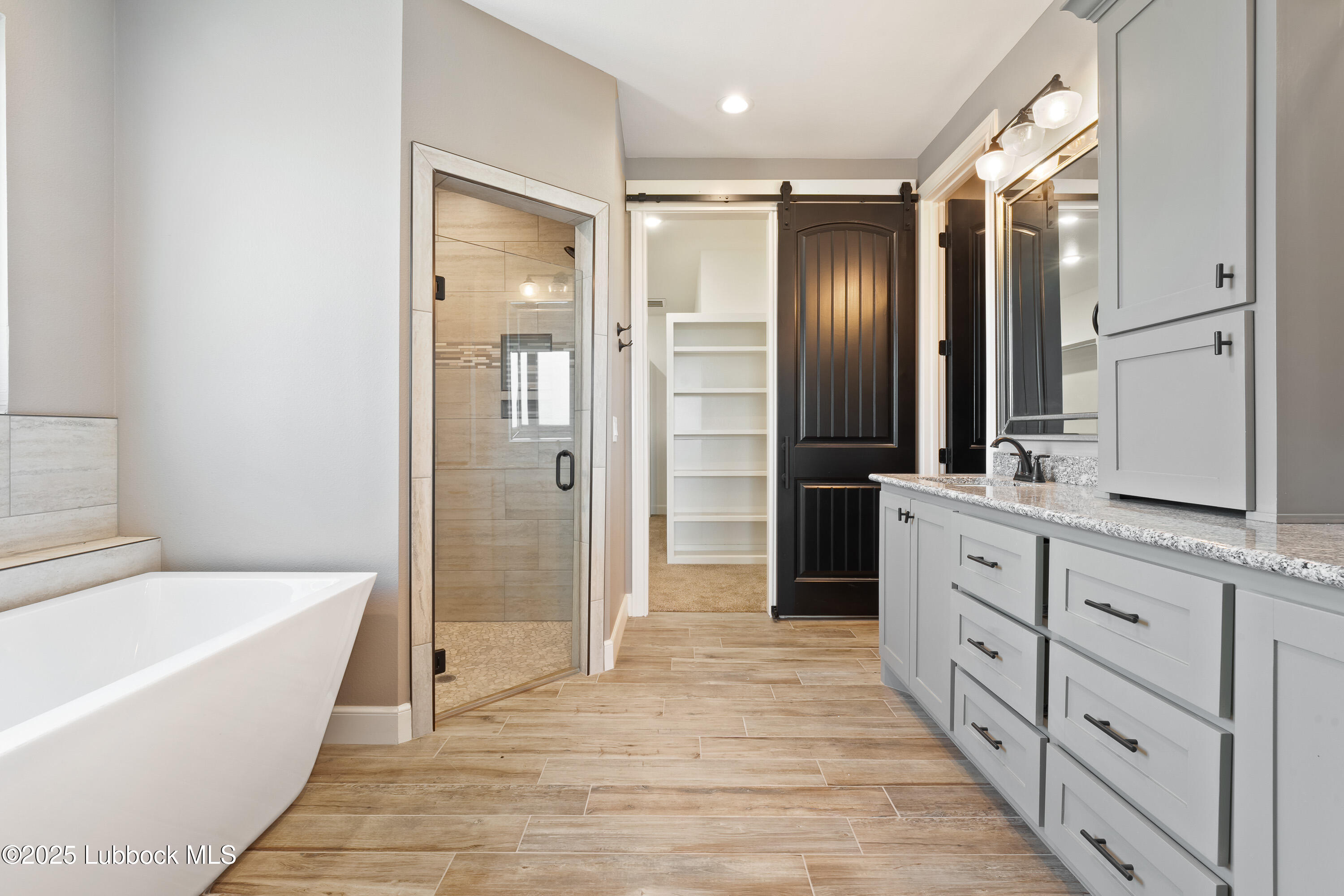 110 Ward Road Snyder, TX 79549 - Photo 14 of 37 a bathroom with a tub a sink and mirrors