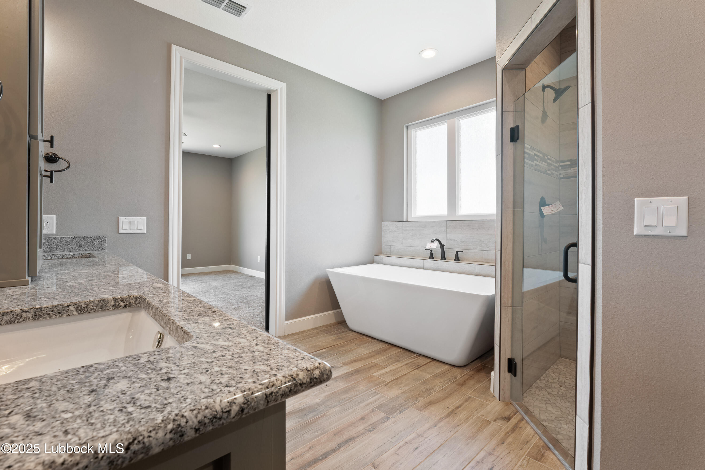 110 Ward Road Snyder, TX 79549 - Photo 16 of 37 a bathroom with a granite countertop sink and mirror with bathtub