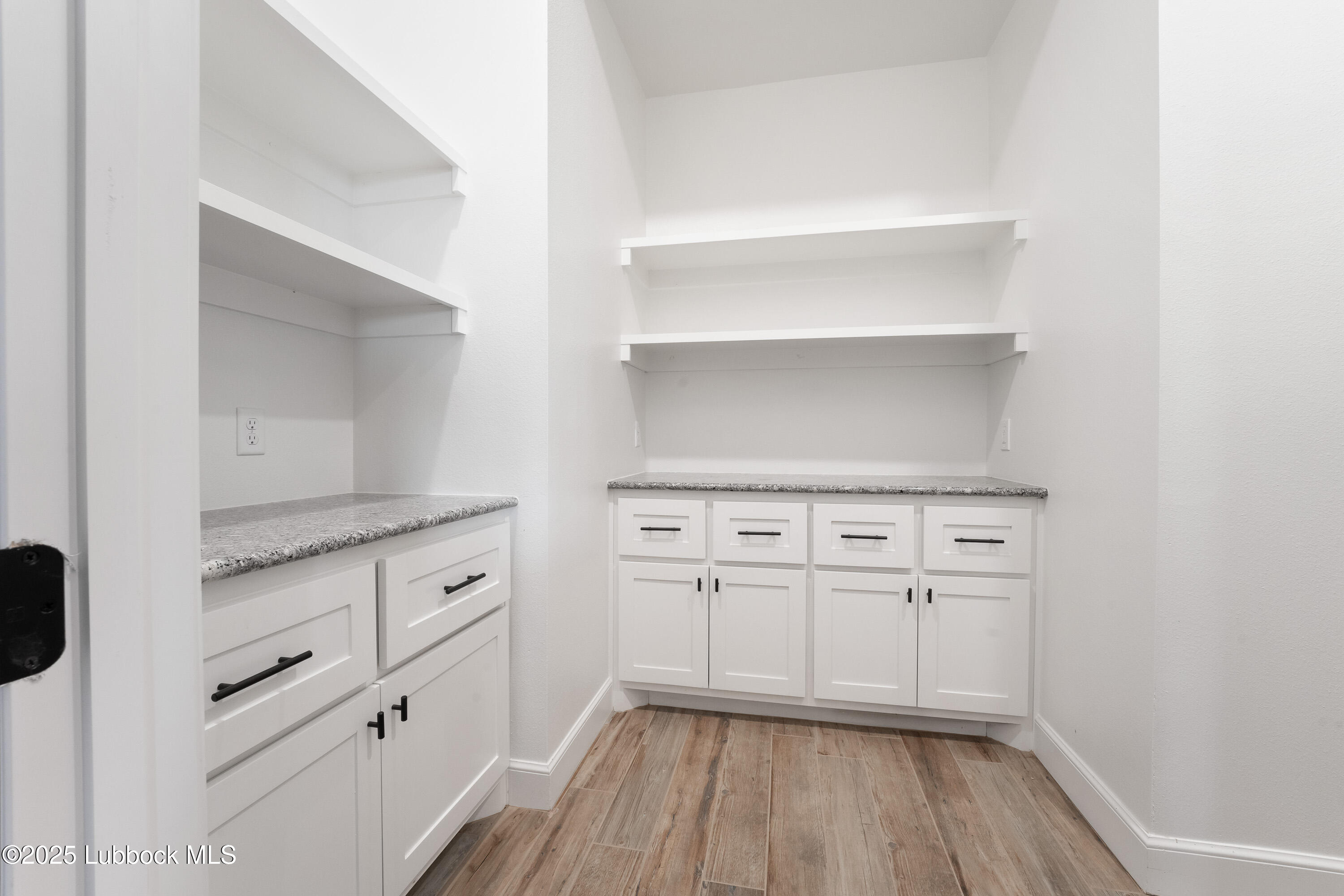110 Ward Road Snyder, TX 79549 - Photo 18 of 37 a kitchen with white cabinets and wooden floor