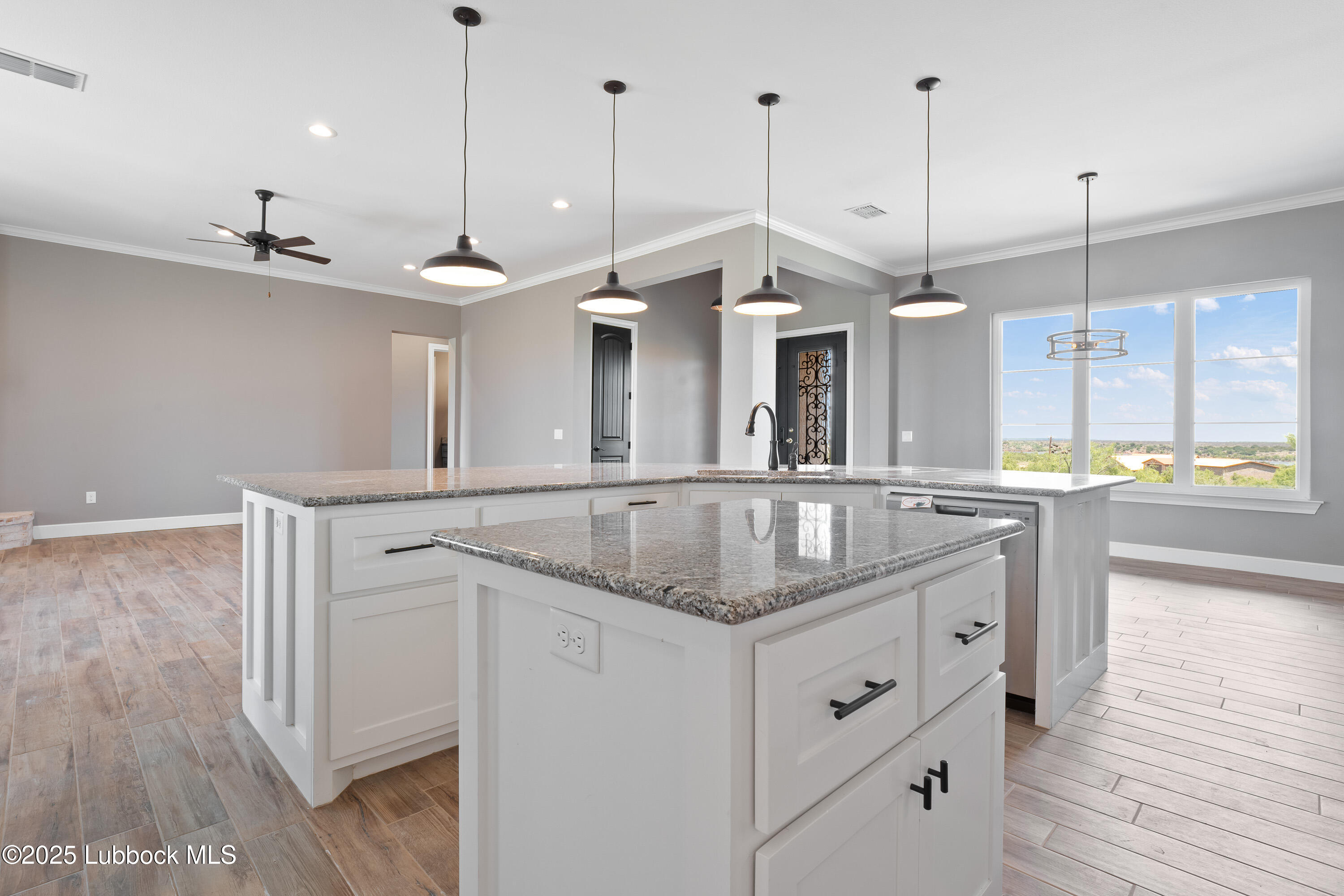 110 Ward Road Snyder, TX 79549 - Photo 10 of 37 a kitchen with stainless steel appliances granite countertop a sink a center island and a wooden floor