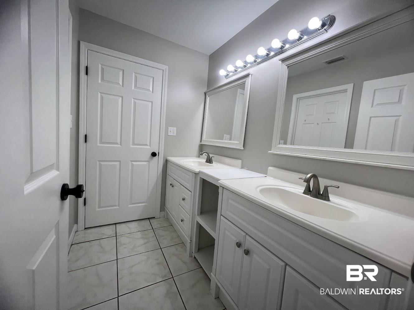 266 Ridgewood Drive Daphne, AL 36526 - Photo 14 of 34 Dual vanity with white cabinetry, integrated sinks, chrome fixtures, and individual framed mirrors