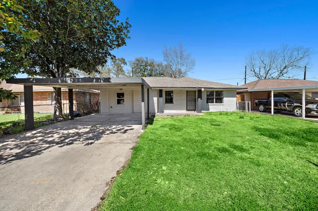 a view of a house with a yard and potted plants