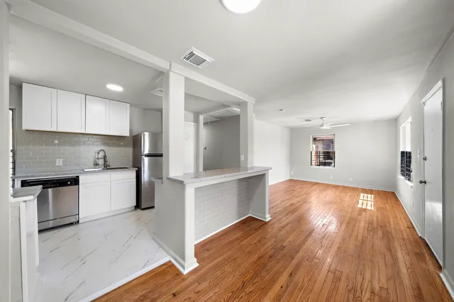 a kitchen with wooden floors and white appliances