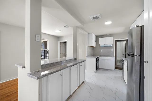a kitchen with stainless steel appliances granite countertop a refrigerator and a sink