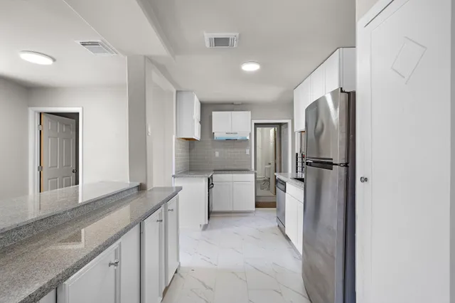 a kitchen with a refrigerator sink and cabinets