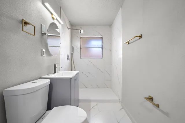 a bathroom with a toilet a sink and shower