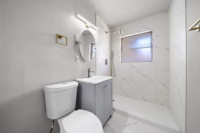 a white toilet sitting next to a bathroom sink