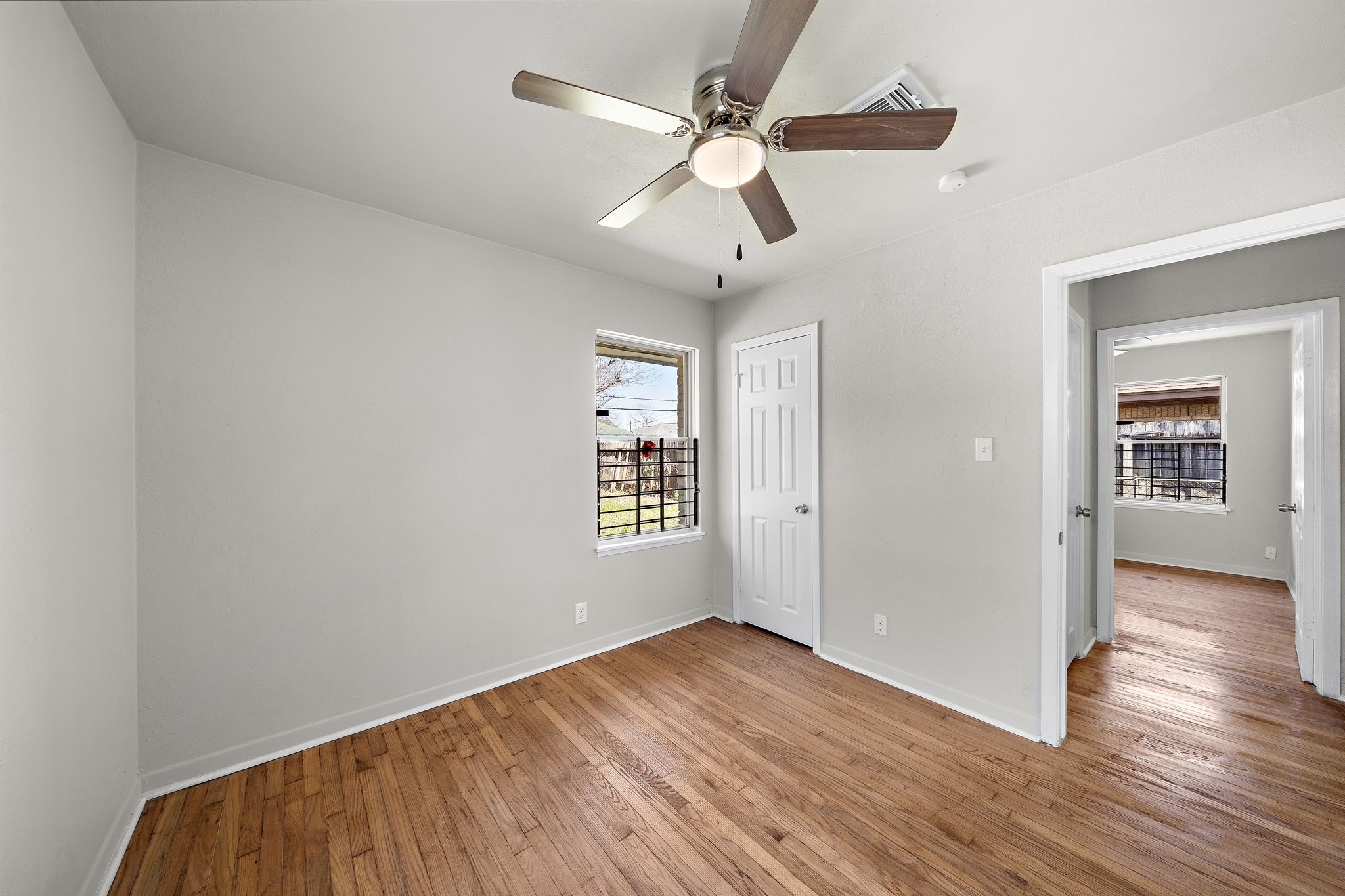 3121 Chimira Lane Houston, TX 77051 - Photo 28 of 35 an empty room with wooden floor ceiling fan and windows