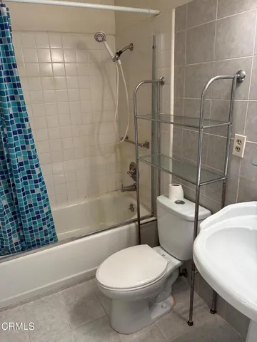 a white toilet sitting next to a bath tub and a shower