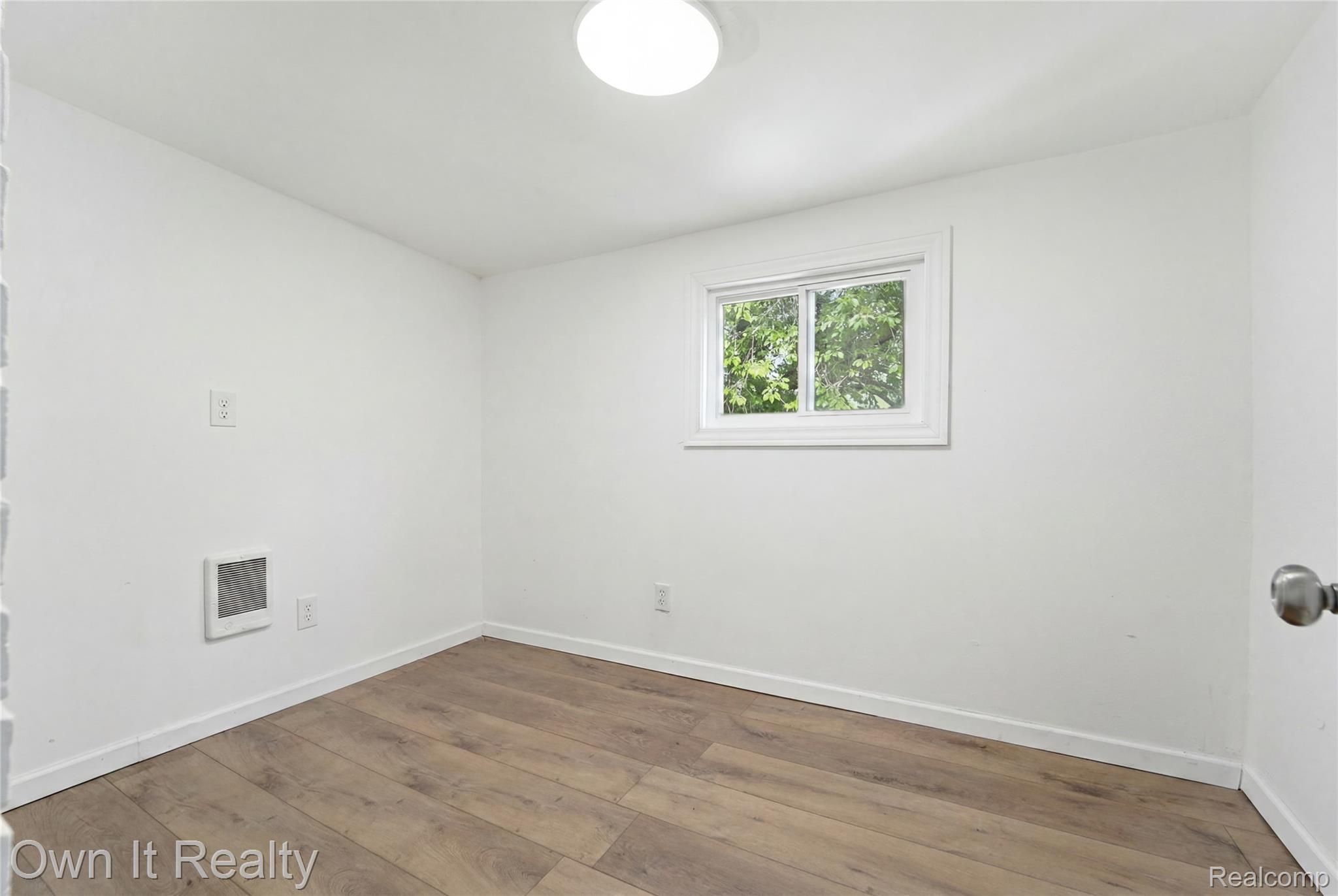17351 Appoline Street Detroit, MI 48235 - Photo 17 of 34 Bright interior room featuring wood-finish flooring, white baseboards, and a white ceiling with a flush-mount light fixture