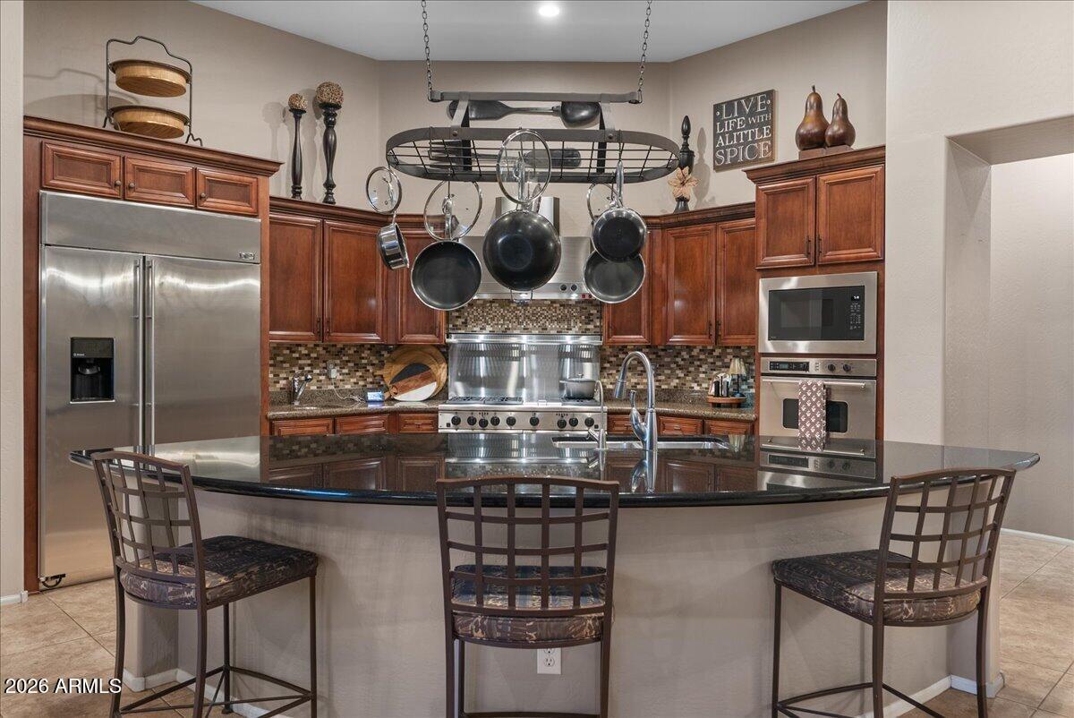 6427 South Magic Court Gilbert, AZ 85298 - Photo 26 of 71 a kitchen with stainless steel appliances granite countertop a sink and cabinets