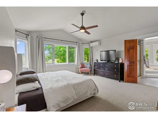 a bedroom with a large bed and a flat tv screen