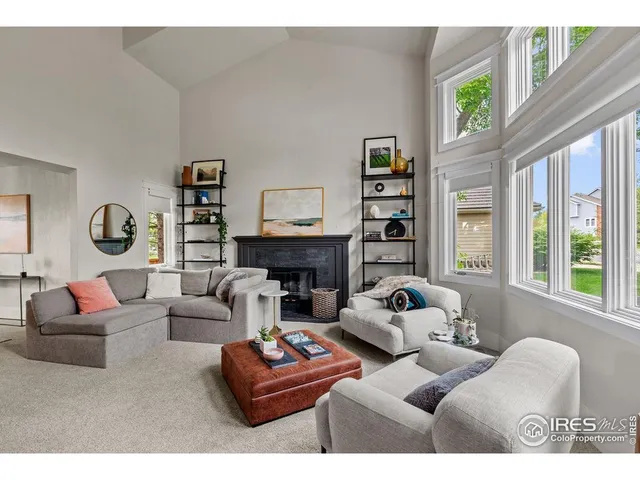 a living room with fireplace furniture and a large window
