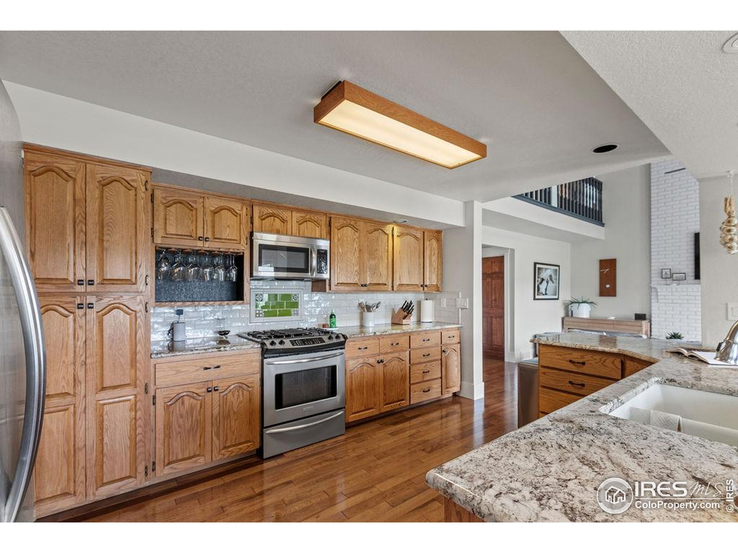 2213 Grosvenor Court Fort Collins, CO 80526 - Photo 9 of 40 a kitchen with stainless steel appliances granite countertop a stove top oven a sink dishwasher a dining table and chairs with wooden floor