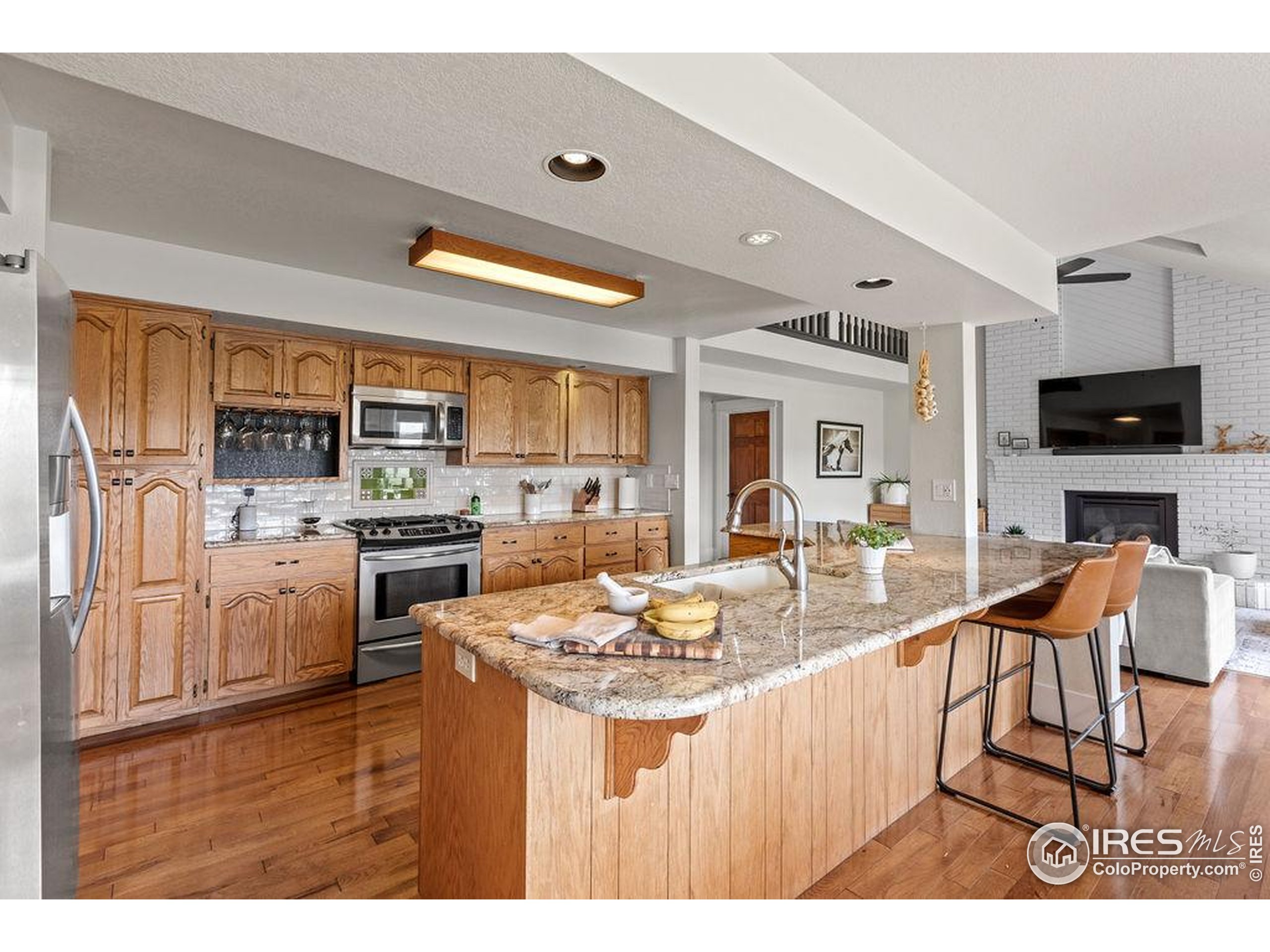 2213 Grosvenor Court Fort Collins, CO 80526 - Photo 10 of 40 a kitchen with stainless steel appliances granite countertop a refrigerator a stove top oven a sink dishwasher and white cabinets with wooden floor