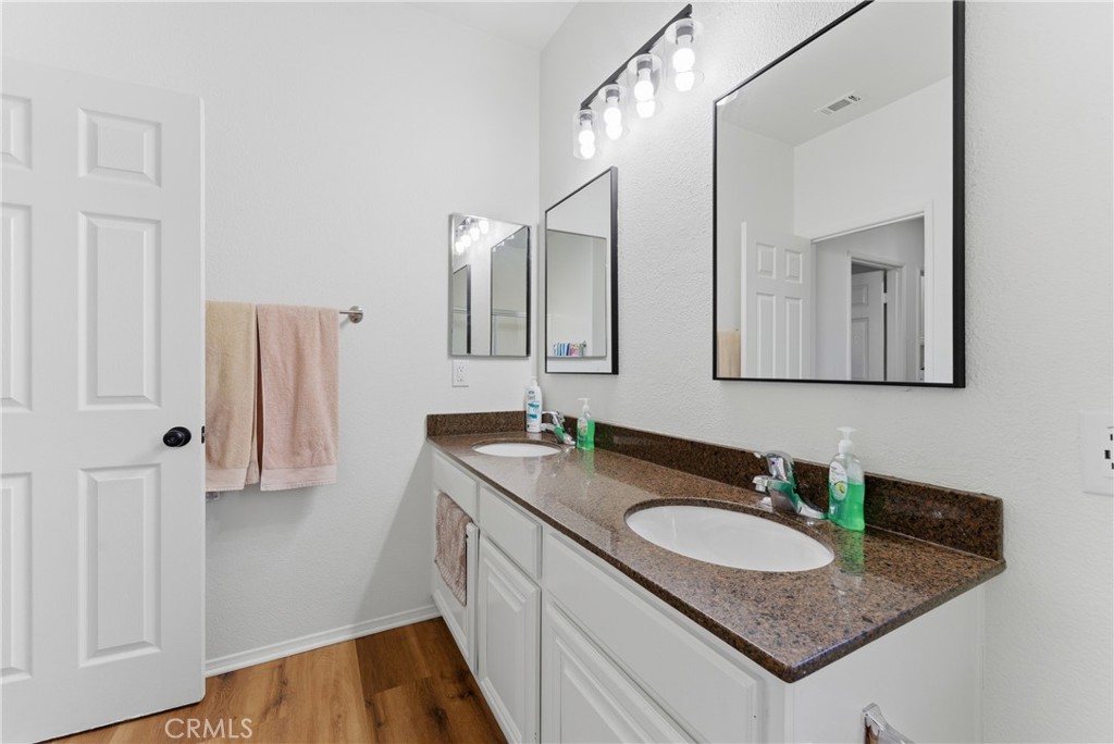 2036 East Jenner Street Lancaster, CA 93535 - Photo 27 of 50 a bathroom with a granite countertop sink and a mirror