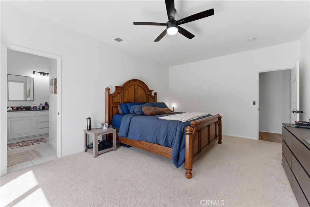 2036 East Jenner Street Lancaster, CA 93535 - Photo 33 of 50 a bedroom with a bed and a chandelier