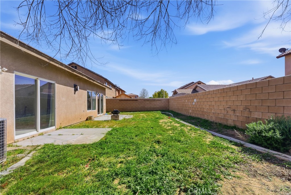 2036 East Jenner Street Lancaster, CA 93535 - Photo 47 of 50 a backyard of a house with lots of green space and wooden fence