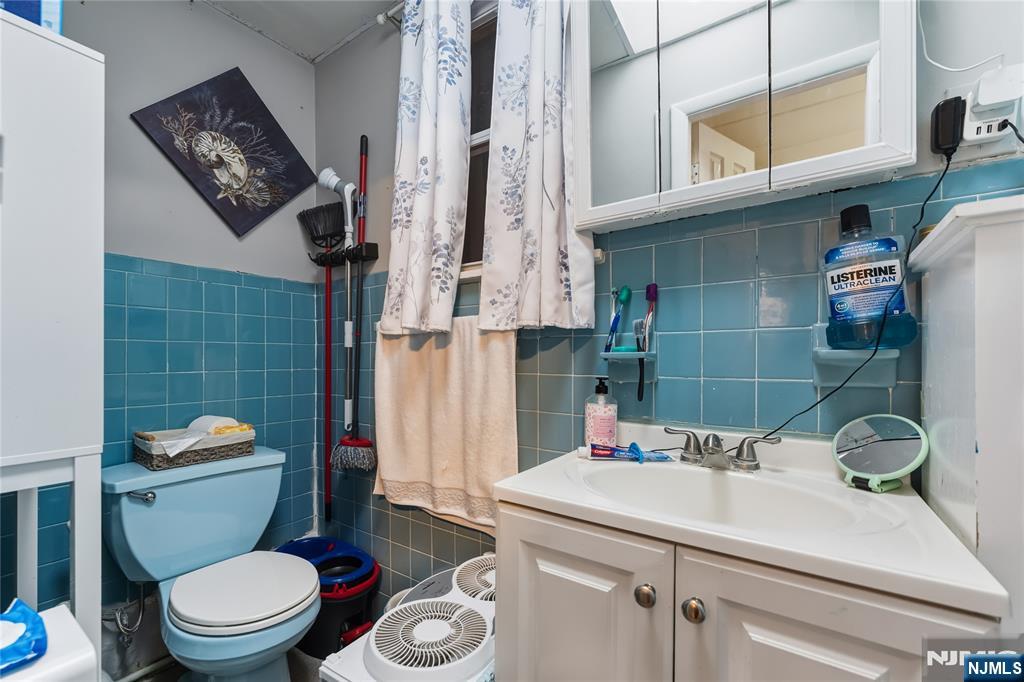 123 47th Street Union City, NJ 07087 - Photo 23 of 27 a bathroom with a sink a toilet and shower curtain