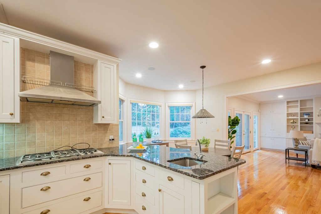 40 Winthrop Road Lexington, MA 02421 - Photo 12 of 42 a kitchen with granite countertop a stove a sink and white cabinets with wooden floor