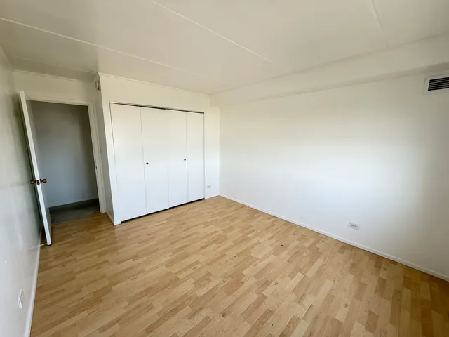 an empty room with wooden floor and mirror