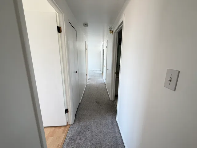 a view of a hallway with wooden cabinets and a hallway
