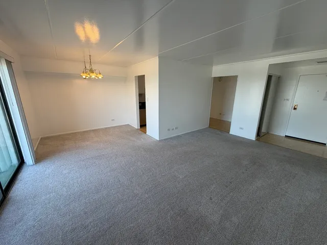 an empty room with a chandelier fan and closet