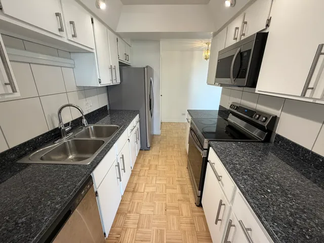 a kitchen with stainless steel appliances granite countertop a sink stove and refrigerator