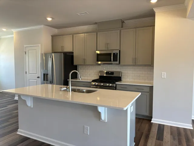 a kitchen with kitchen island a sink appliances and cabinets