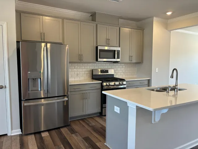 a kitchen with stainless steel appliances granite countertop a refrigerator sink and microwave