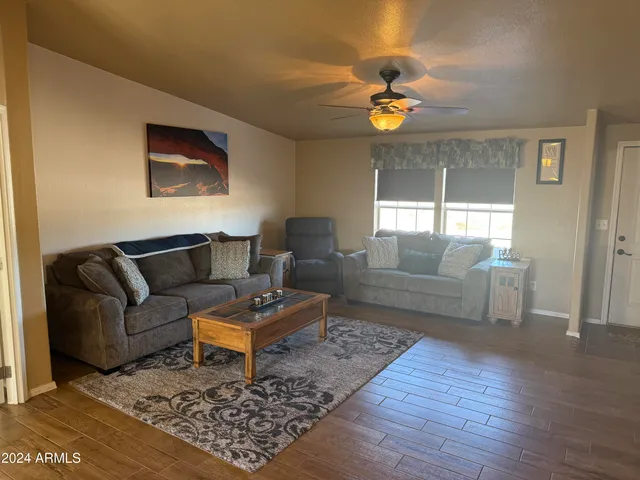 a view of an empty room with window and chandelier fan