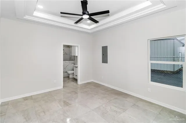 a view of empty room with wooden floor and ceiling fan