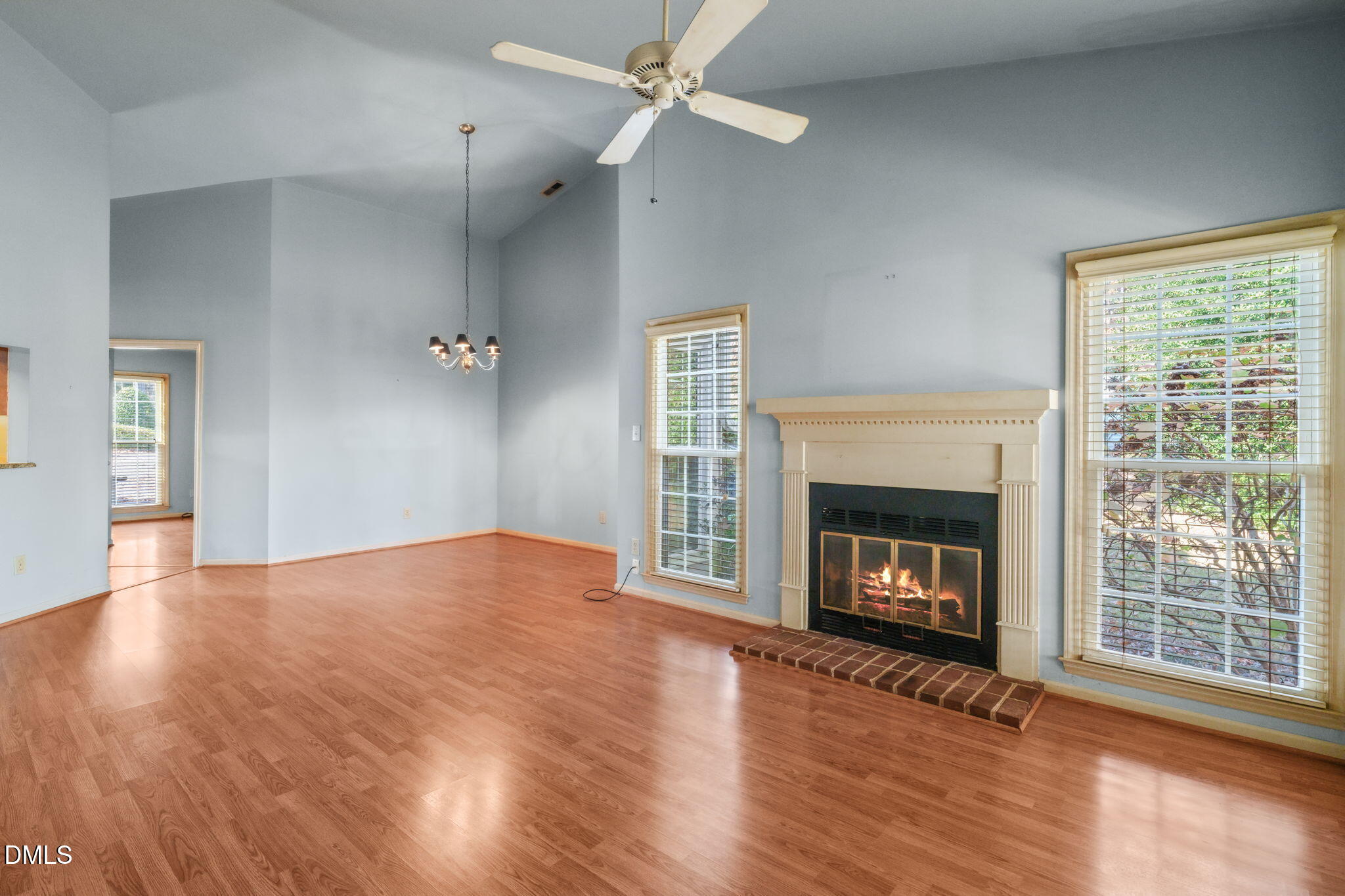 1212 Berley Court Raleigh, NC 27609 - Photo 9 of 38 an empty room with wooden floor fireplace cabinet and windows
