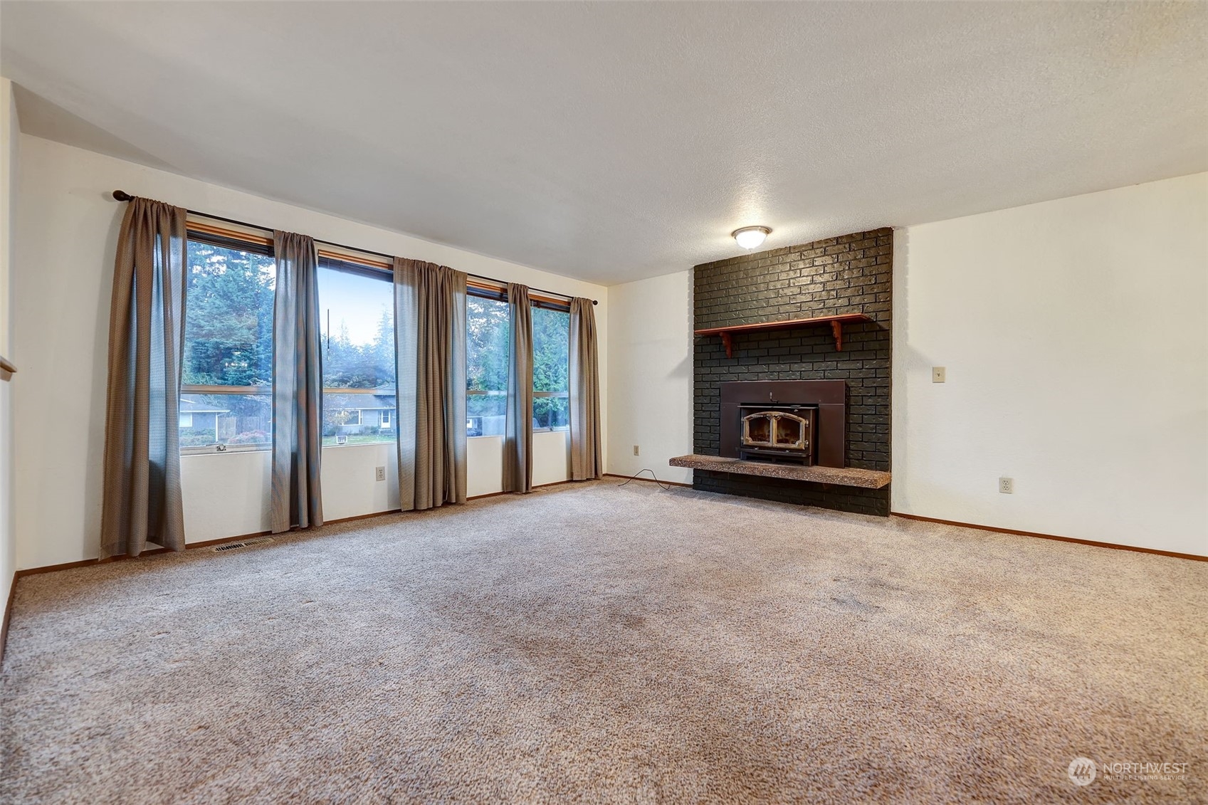 17206 30th Drive Southeast Bothell, WA 98012 - Photo 3 of 40 a view of an empty room with a fireplace and a window