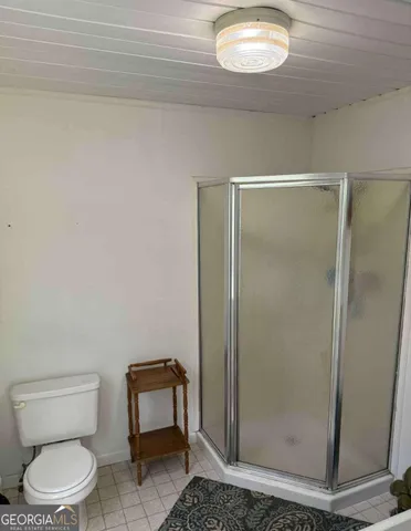 a bathroom with a toilet and a shower
