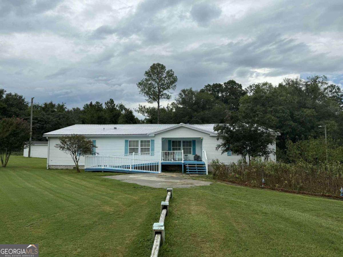 289 Mason Dixon Line Road, Unit 3 Ashburn, GA 31714 - Photo 3 of 32 a view of a white house with a big yard and potted plants