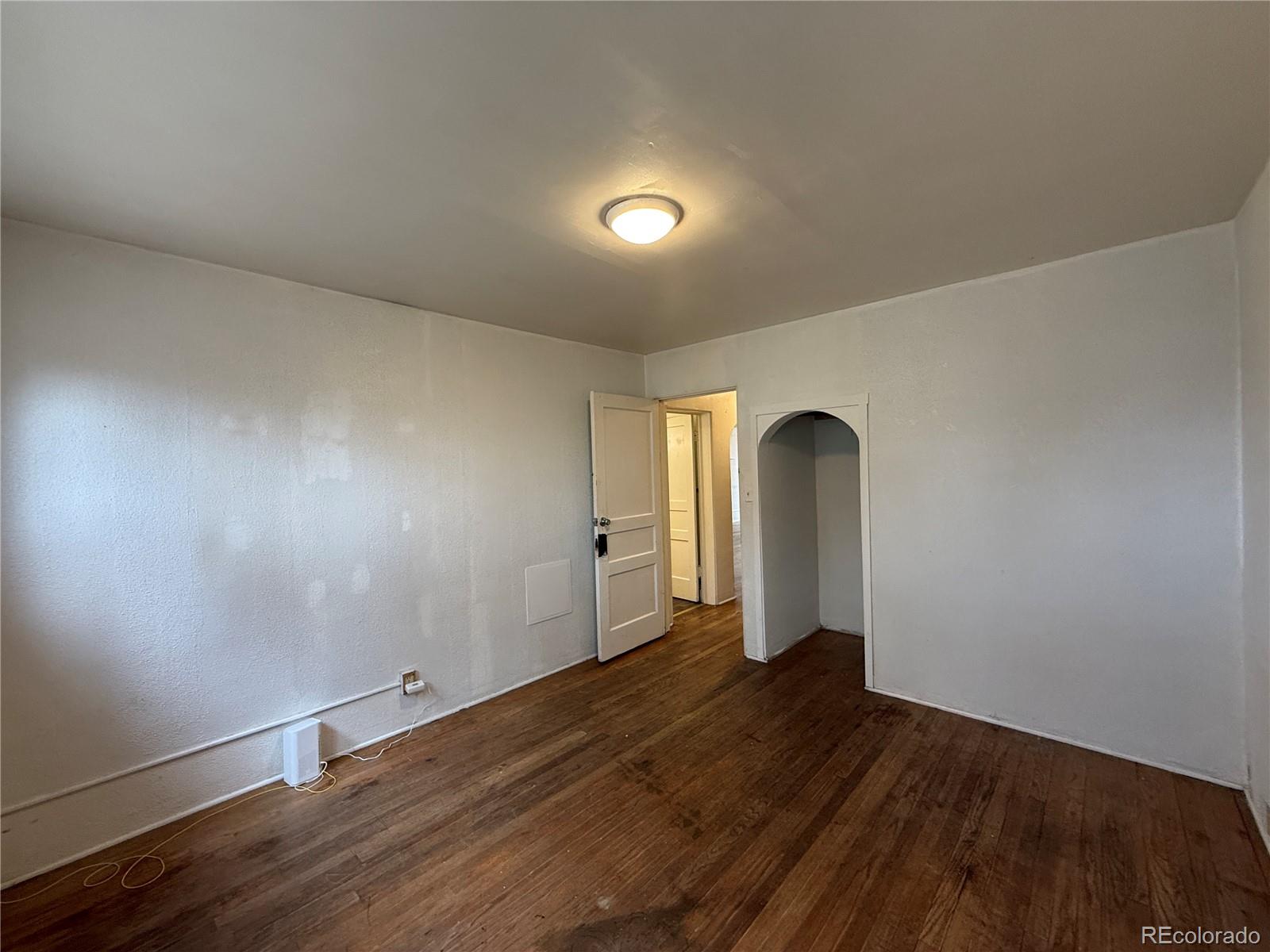 134 West 3rd Street Center, CO 81125 - Photo 9 of 13 an empty room with wooden floor and windows