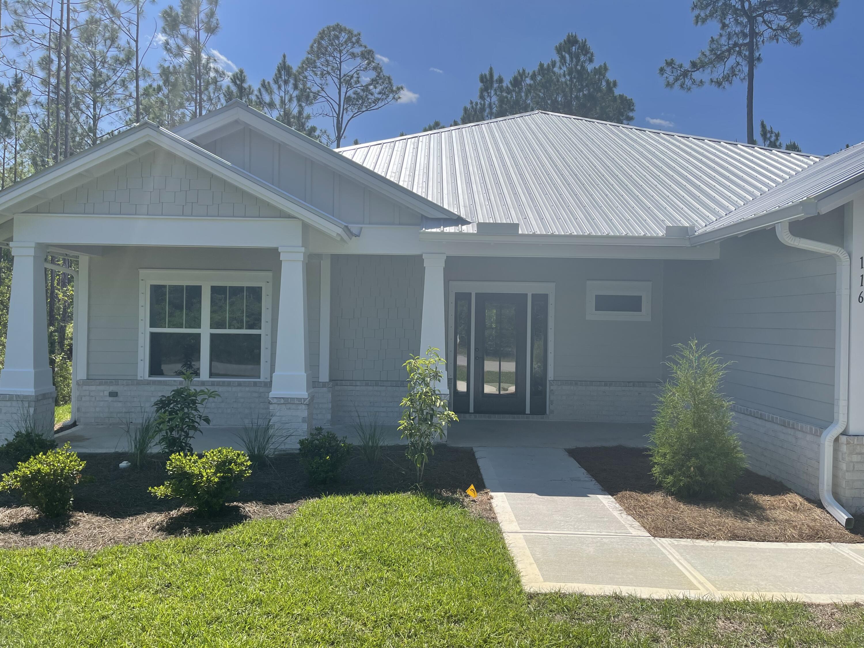 116 Bear Creek Boulevard Freeport, FL 32439 - Photo 2 of 16 a front view of a house with garden