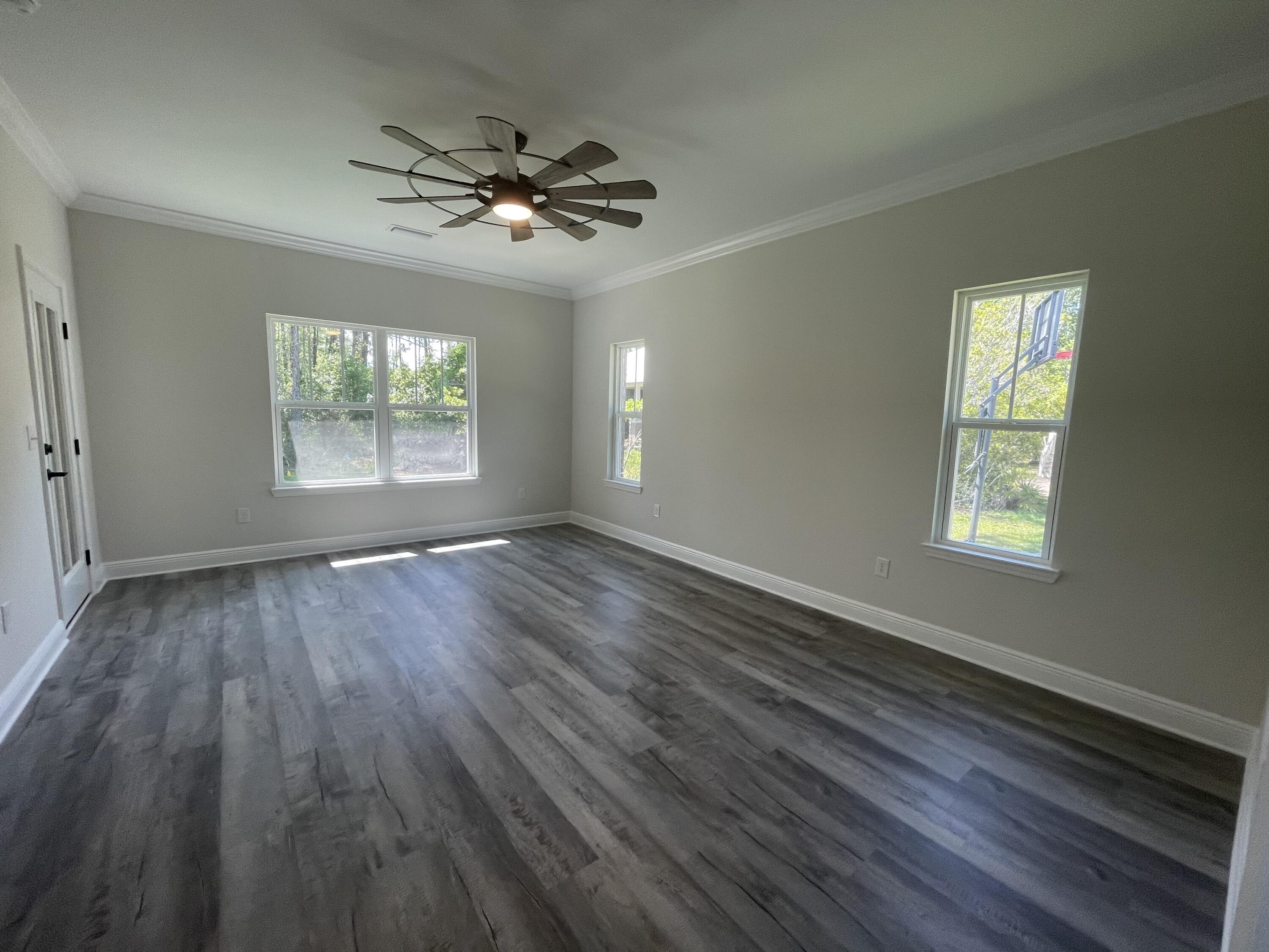 116 Bear Creek Boulevard Freeport, FL 32439 - Photo 5 of 16 a view of an empty room with wooden floor and a window