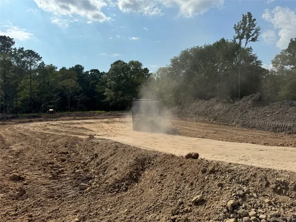 a view of a yard with trees in the background