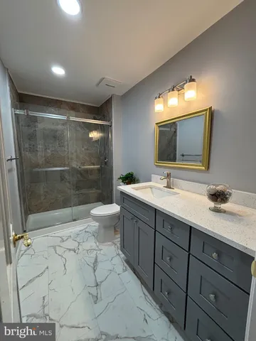 a bathroom with a double vanity sink toilet and shower