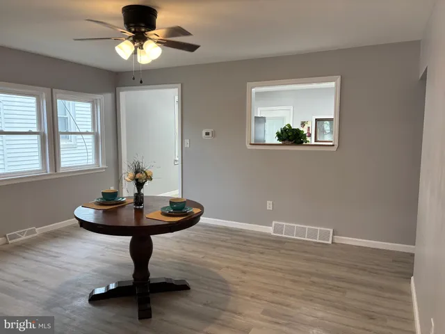 a view of a room with a chandelier and wooden floor